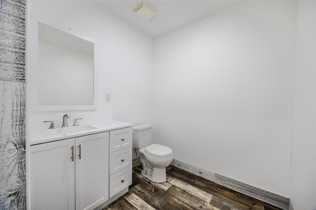 bathroom featuring vanity, hardwood / wood-style flooring, and toilet