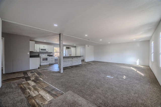 unfurnished living room featuring dark colored carpet