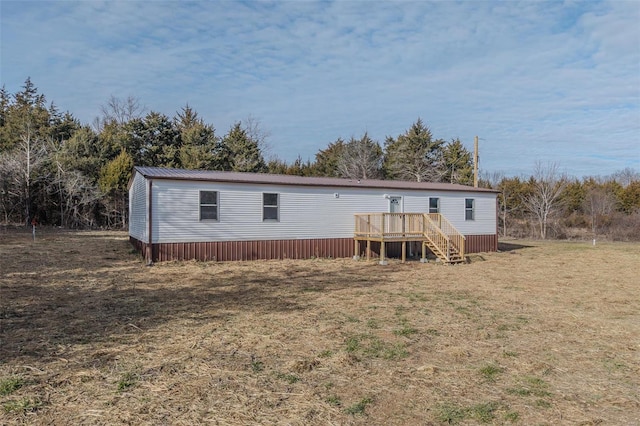 back of property with a lawn and a deck