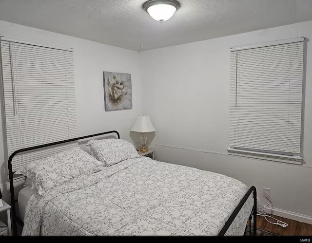 bedroom with dark wood-type flooring and a textured ceiling