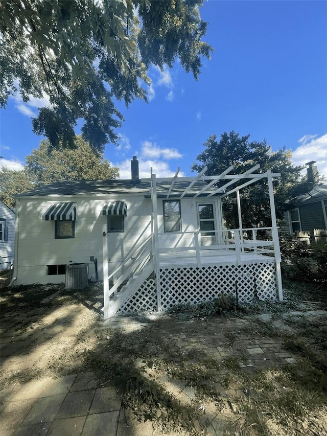 back of house with a deck and central air condition unit