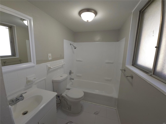 full bathroom featuring vanity, tile walls, toilet, and shower / bath combination