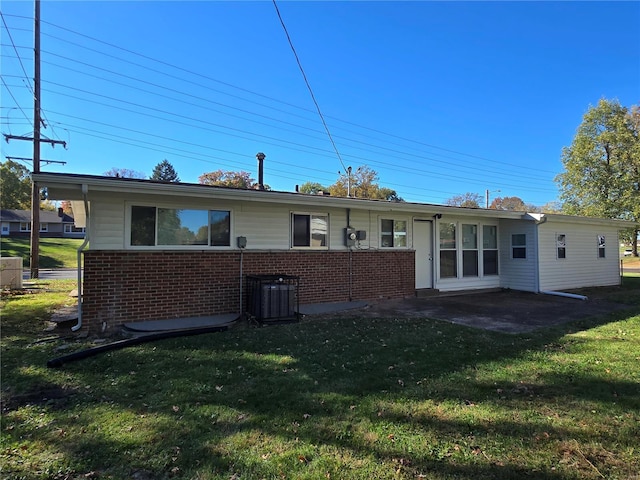 rear view of house with a yard, central AC unit, and a patio area