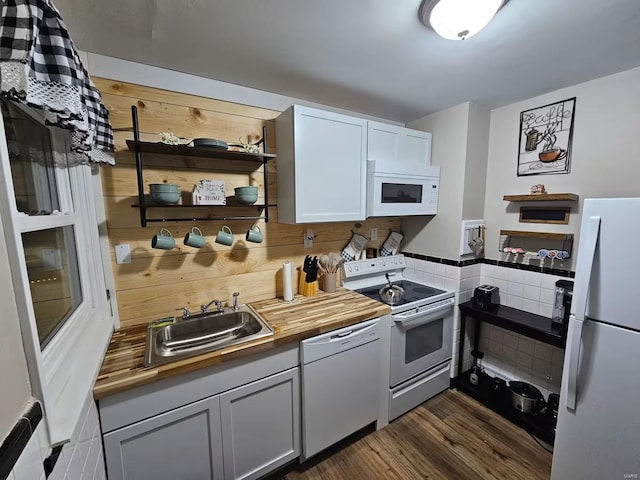 kitchen with wood counters, white appliances, dark wood-type flooring, sink, and white cabinetry