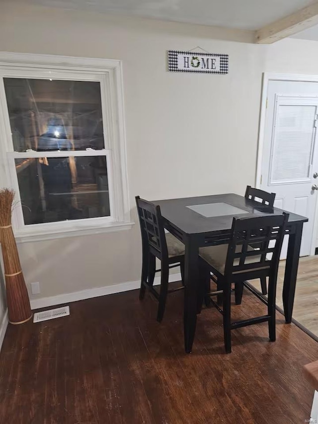 dining room featuring beamed ceiling and wood-type flooring