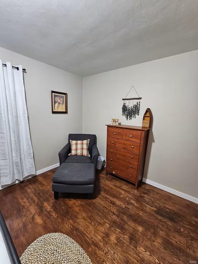 sitting room featuring dark hardwood / wood-style flooring and a textured ceiling