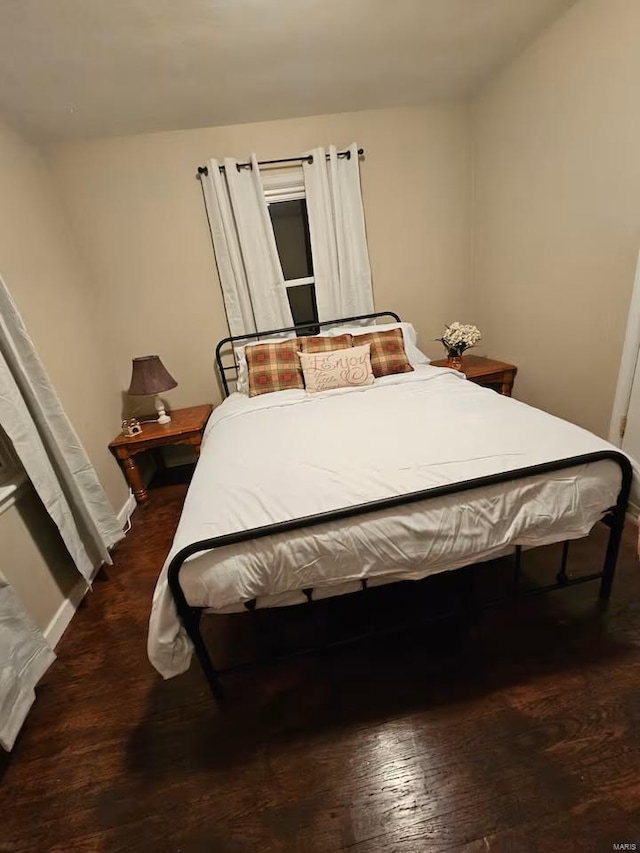 bedroom with dark wood-type flooring