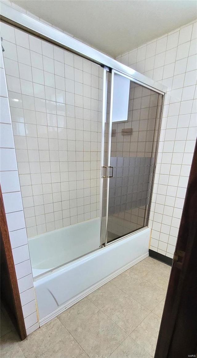 bathroom with tile patterned flooring and combined bath / shower with glass door