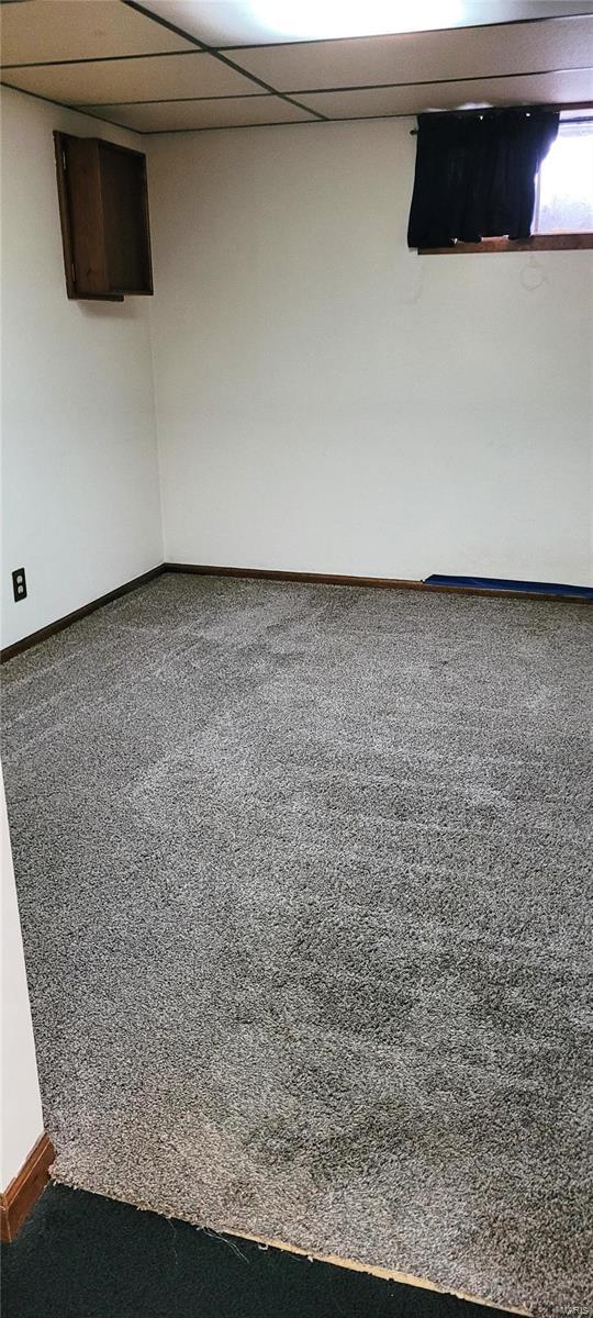 unfurnished room featuring a paneled ceiling and carpet floors