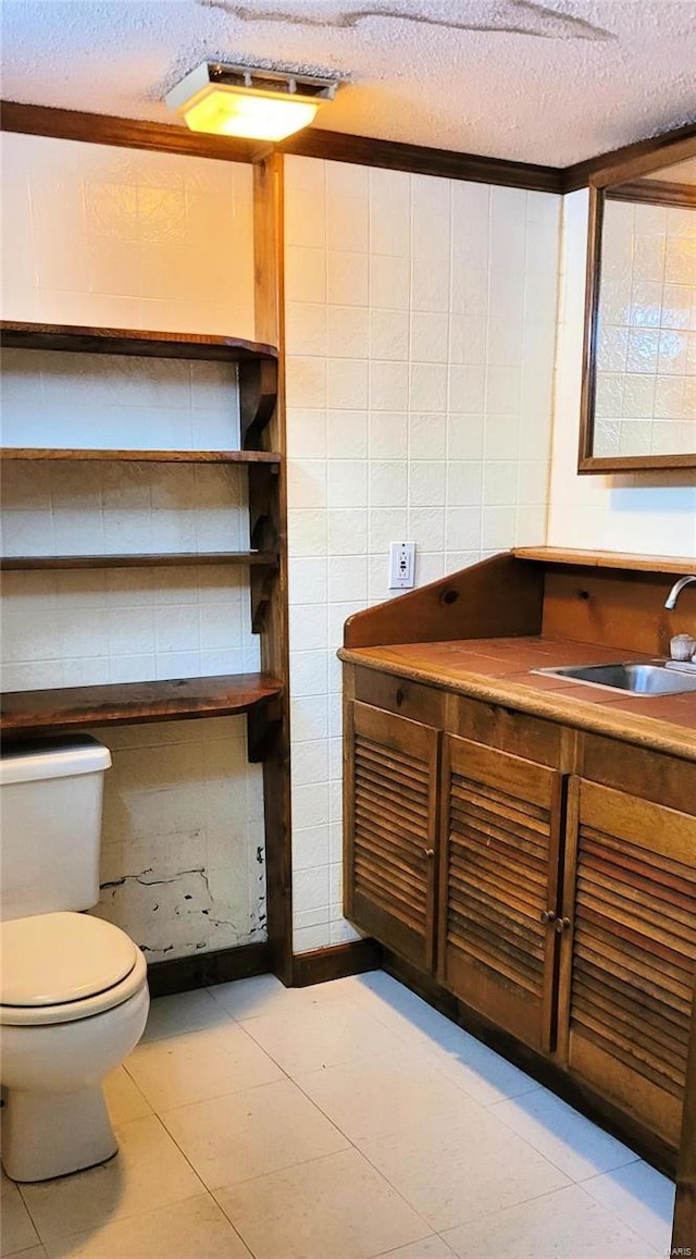 bathroom with vanity, a textured ceiling, and toilet