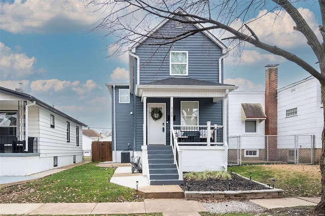 view of front facade with a porch, a front lawn, and central air condition unit