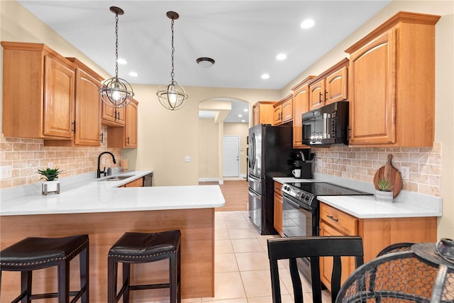 kitchen featuring kitchen peninsula, tasteful backsplash, sink, black appliances, and light tile patterned floors