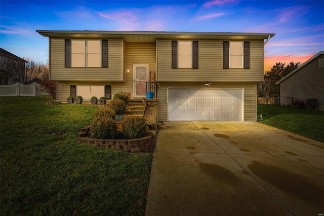 split foyer home featuring a yard and a garage