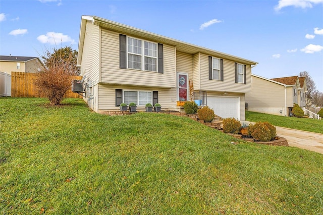 raised ranch with a garage and a front lawn