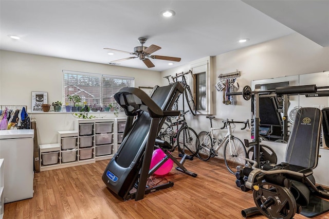 exercise area with ceiling fan and light hardwood / wood-style floors