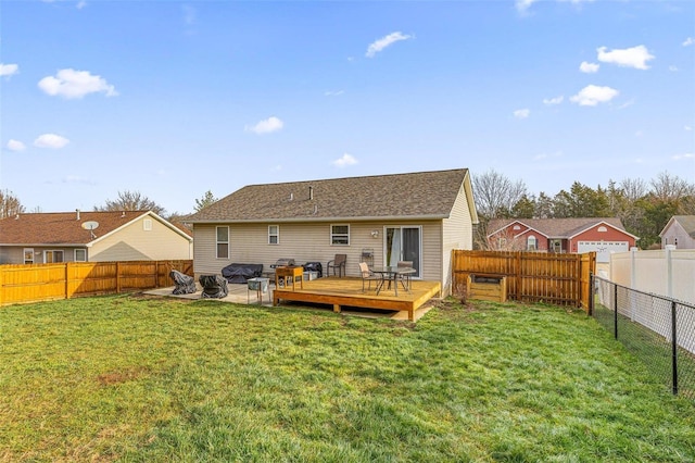 rear view of house featuring a lawn and a wooden deck