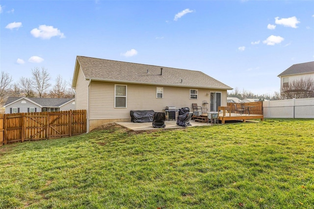 back of house with a deck, a yard, and a patio