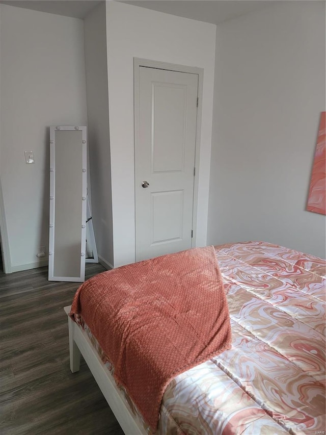 bedroom with dark hardwood / wood-style flooring