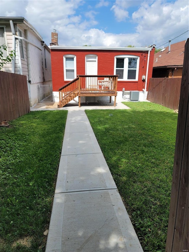 view of front facade featuring central AC, a deck, and a front lawn