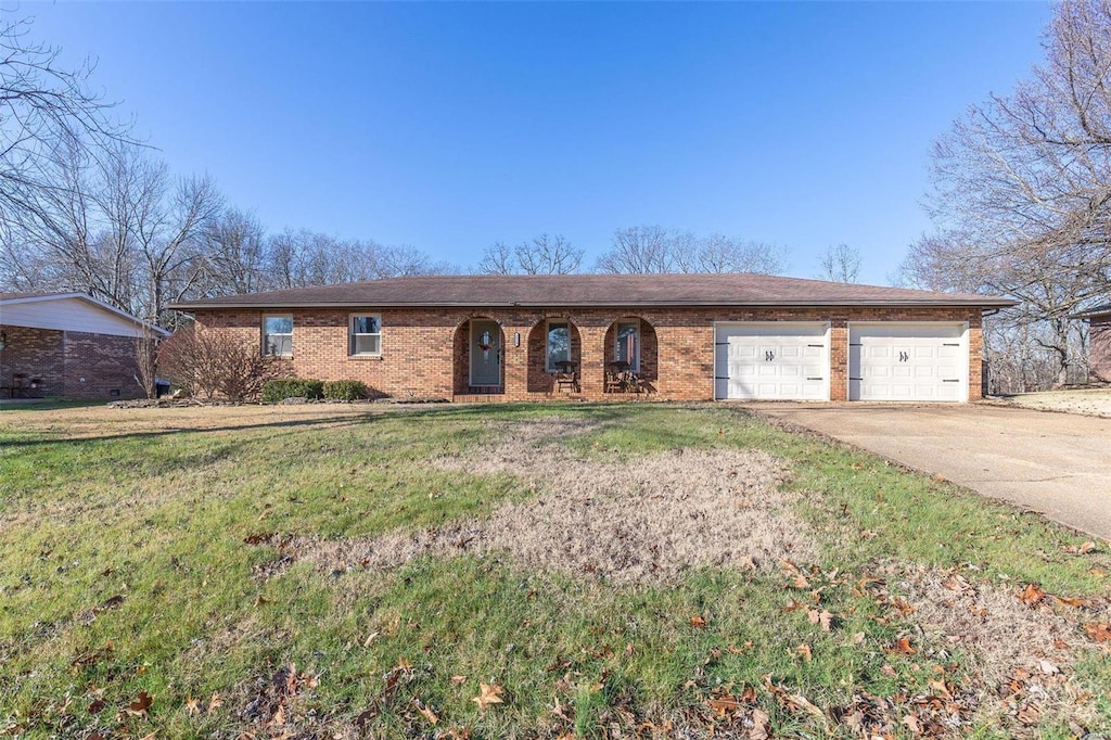 ranch-style home with a garage and a front lawn