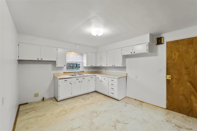 kitchen featuring white cabinetry and sink