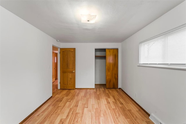 unfurnished bedroom with light wood-type flooring and a closet