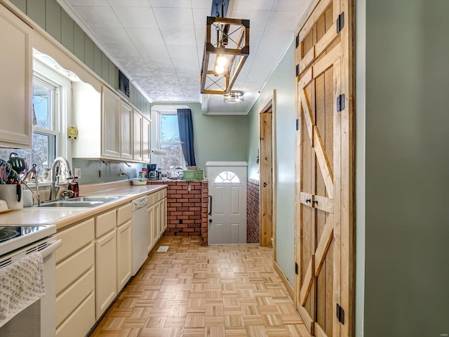 kitchen with white appliances, light countertops, crown molding, pendant lighting, and a sink