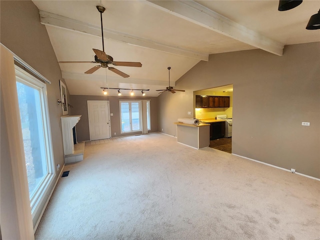 unfurnished living room with carpet, a fireplace with raised hearth, vaulted ceiling with beams, and baseboards