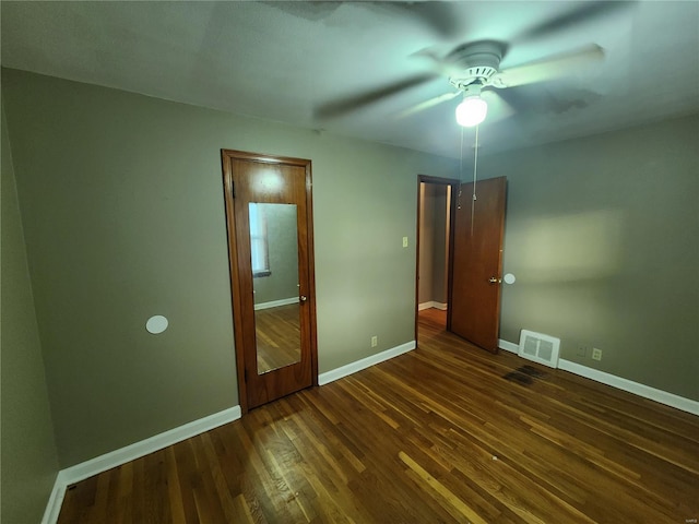 unfurnished bedroom with ceiling fan, baseboards, visible vents, and dark wood finished floors