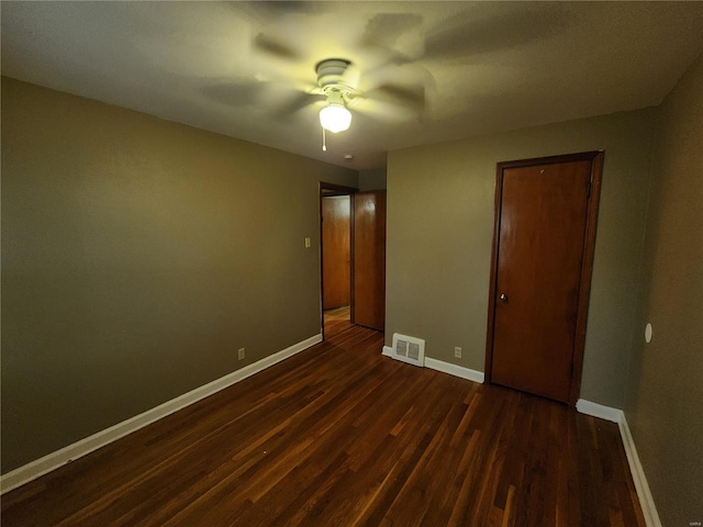 unfurnished bedroom featuring visible vents, dark wood finished floors, baseboards, and ceiling fan