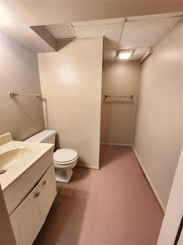 bathroom with vanity, a drop ceiling, and toilet