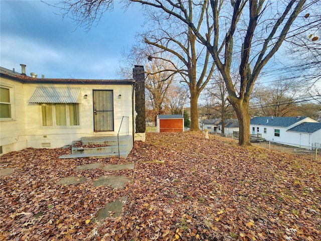 view of home's exterior with crawl space, fence, and a chimney