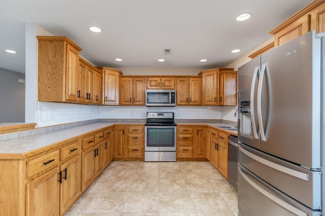 kitchen featuring sink, backsplash, and appliances with stainless steel finishes