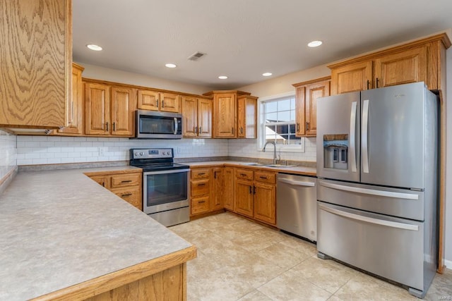 kitchen featuring light tile patterned floors, stainless steel appliances, tasteful backsplash, and sink