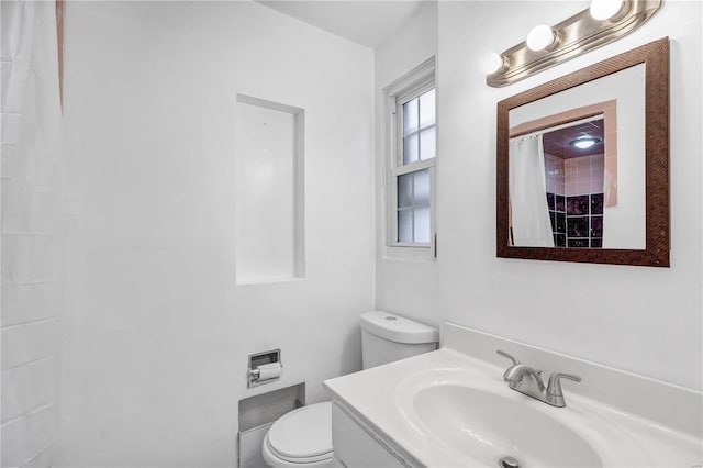 bathroom featuring vanity, toilet, and walk in shower