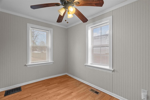 empty room featuring light hardwood / wood-style floors, ceiling fan, and crown molding