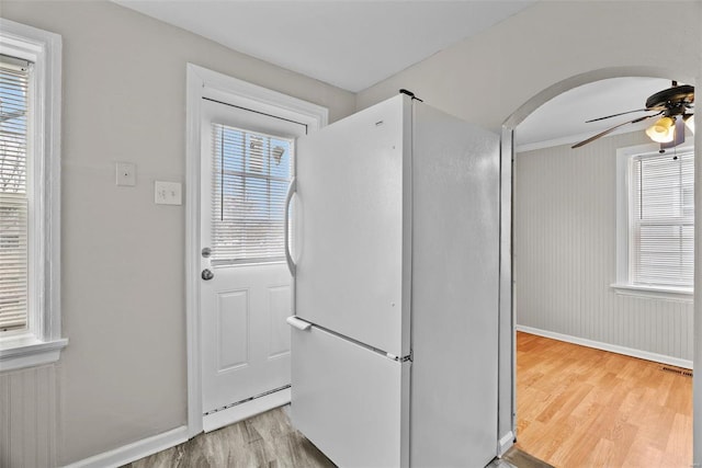 entryway featuring hardwood / wood-style flooring, ceiling fan, and crown molding