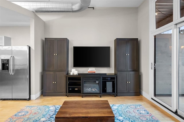 living area featuring light wood-type flooring and baseboards