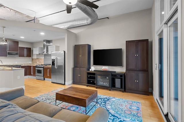 living room featuring light wood-style floors and a high ceiling