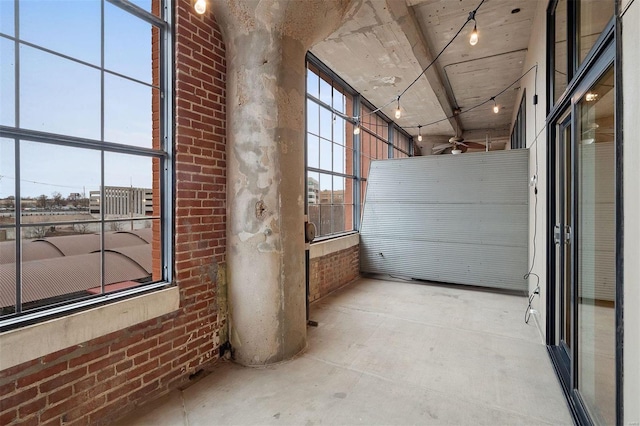 corridor featuring brick wall and concrete flooring