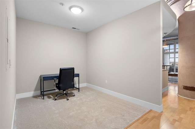 office featuring baseboards, visible vents, and wood finished floors