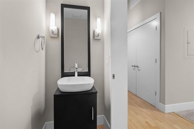 bathroom featuring baseboards, wood finished floors, and vanity