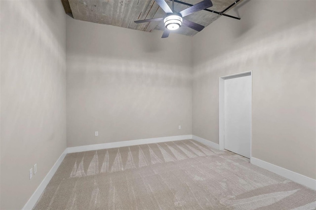 empty room with a ceiling fan, carpet, and baseboards