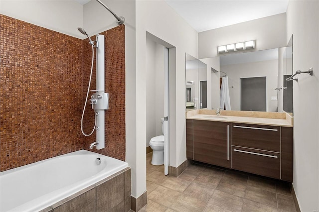 bathroom featuring tiled shower / bath combo, vanity, and toilet