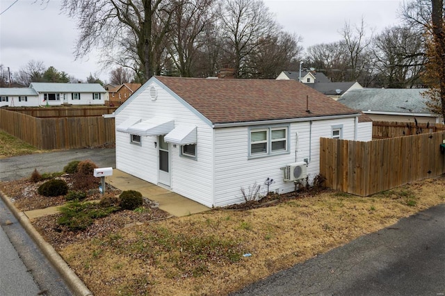 view of side of property featuring a wall mounted air conditioner and ac unit