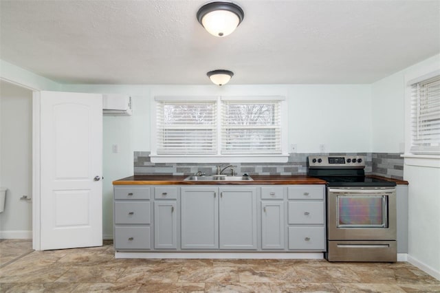 kitchen with backsplash, wood counters, sink, and stainless steel range with electric cooktop