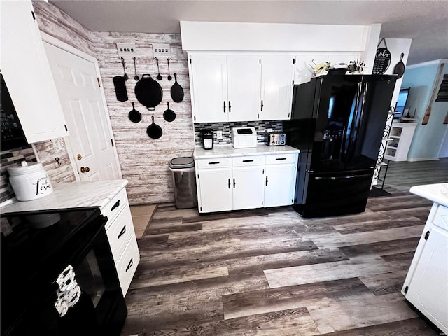 kitchen featuring black appliances, decorative backsplash, white cabinets, and dark wood-type flooring