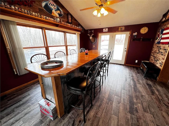 dining space featuring french doors, lofted ceiling, ceiling fan, and dark wood-type flooring