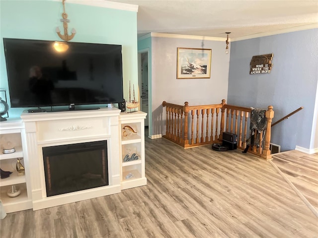 living room with wood-type flooring and ornamental molding