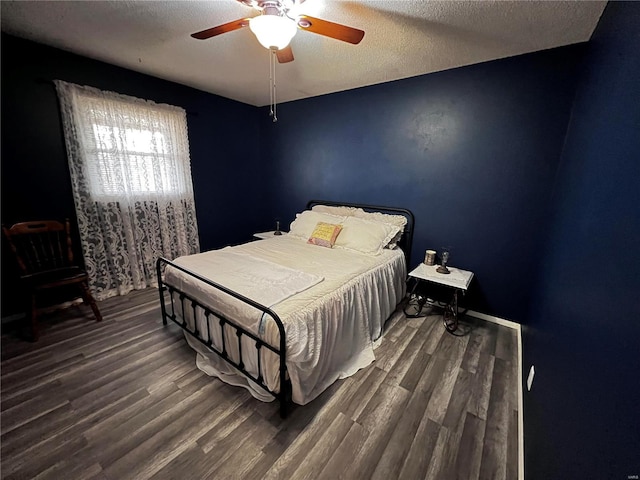 bedroom featuring ceiling fan, dark wood-type flooring, and a textured ceiling